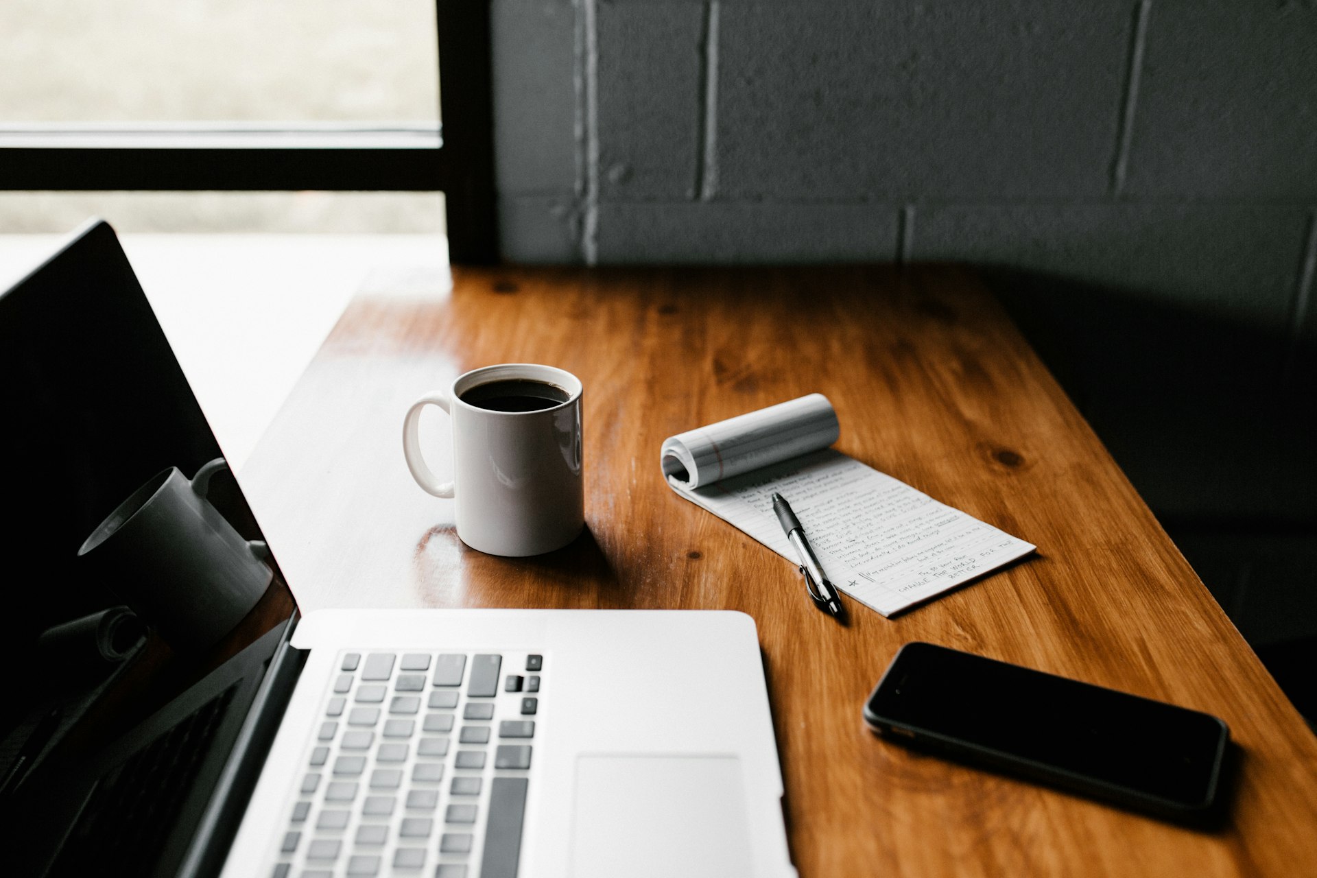 Bureau met laptop, koffiemok en smartphone